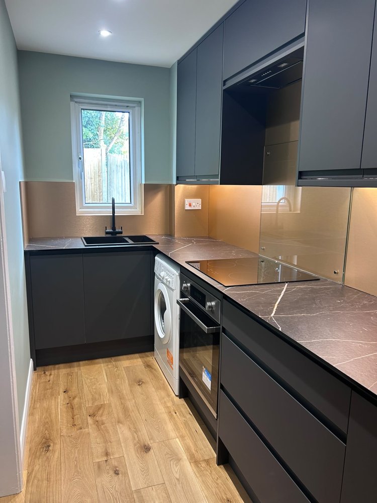 The finished kitchen in Brighton Hill with dark units and oak-effect flooring